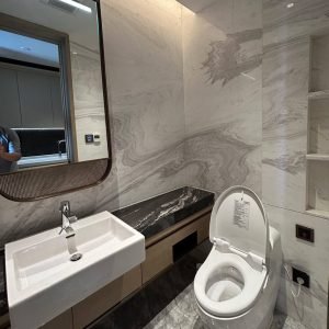 Modern-bathroom-with-marble-walls-and-floors-featuring-a-white-sink-and-toilet-dubai